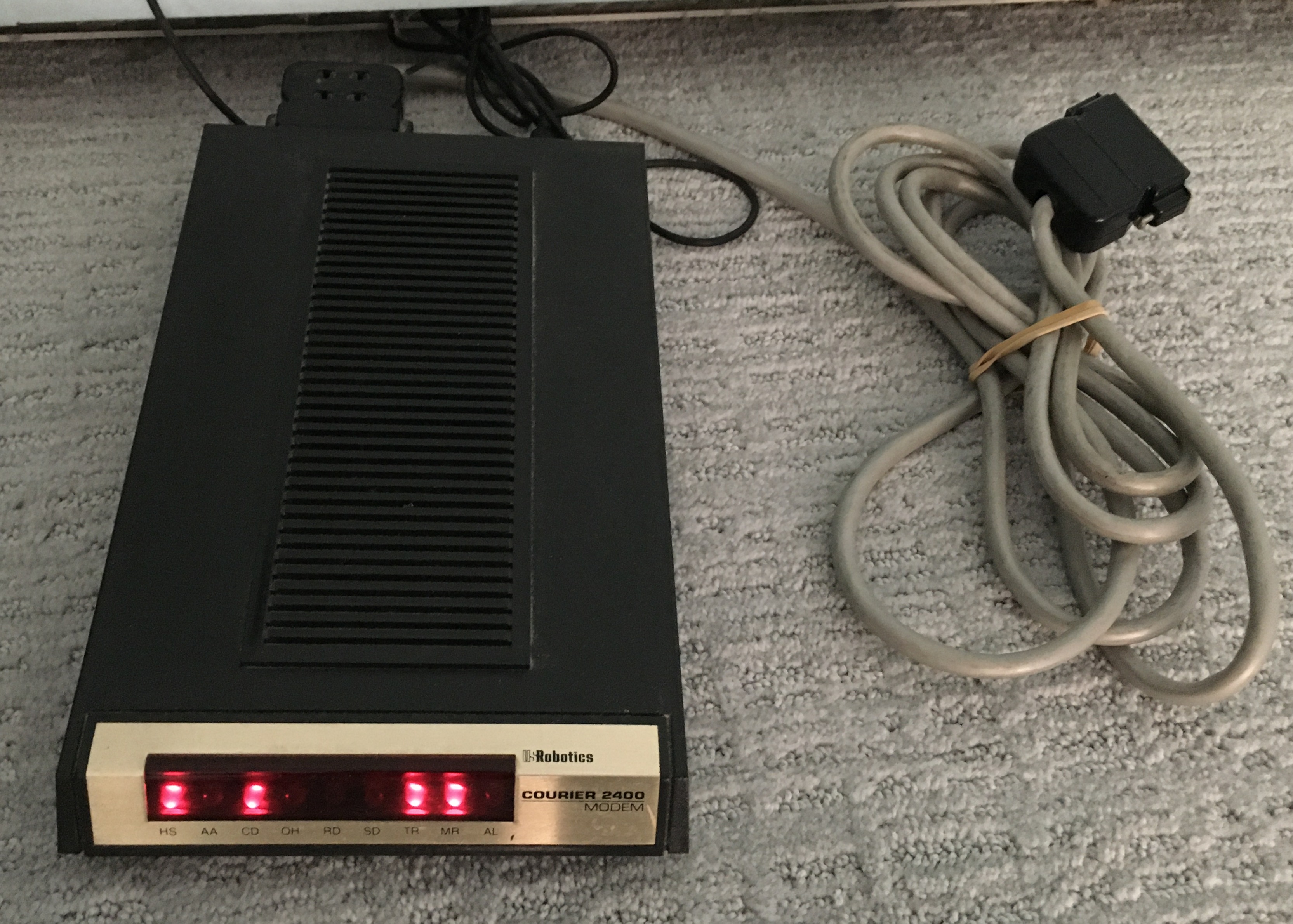 Courier 2400 modem with status lights and a serial cable